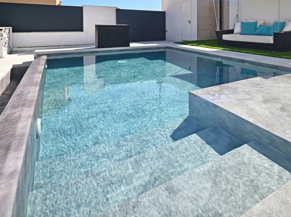 Jardin résidentiel avec piscine rectangulaire à débordement, revêtement de terrasse en carrelage imitation bois
