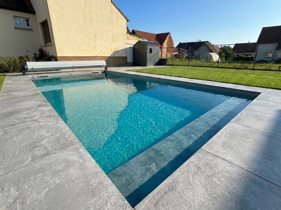 Chantier de construction en extérieur avec ouvriers en équipements de protection individuelle travaillant sur une dalle béton