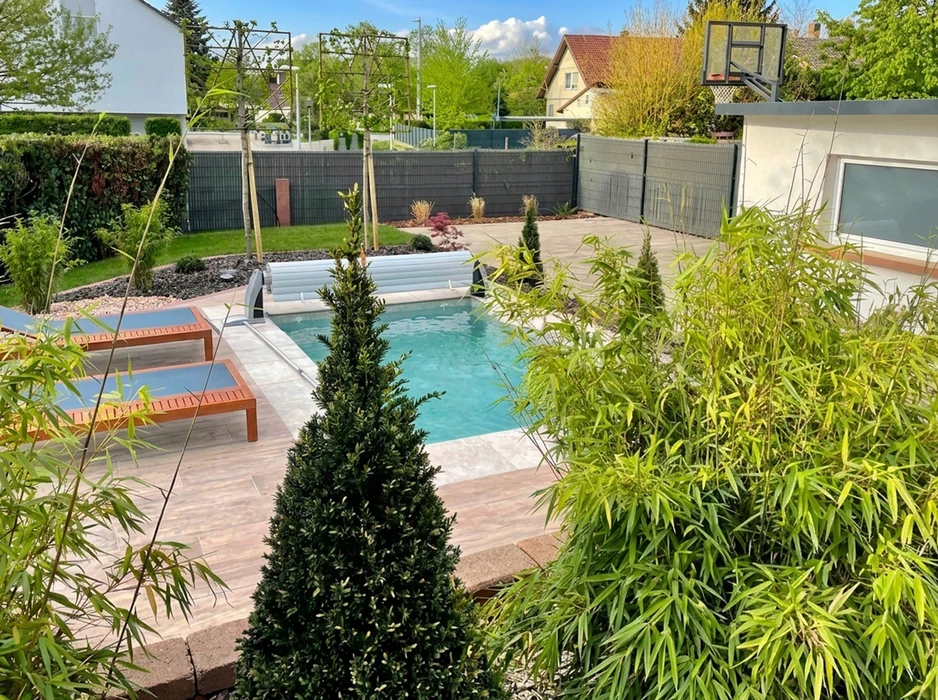 Piscine extérieure rectangulaire avec liner gris, entourée d'une plage en composite gris anthracite et d'une terrasse en bois exotique